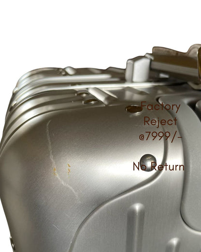 Metallic object with 'Factory Reject' and 'No Return' text on a white background