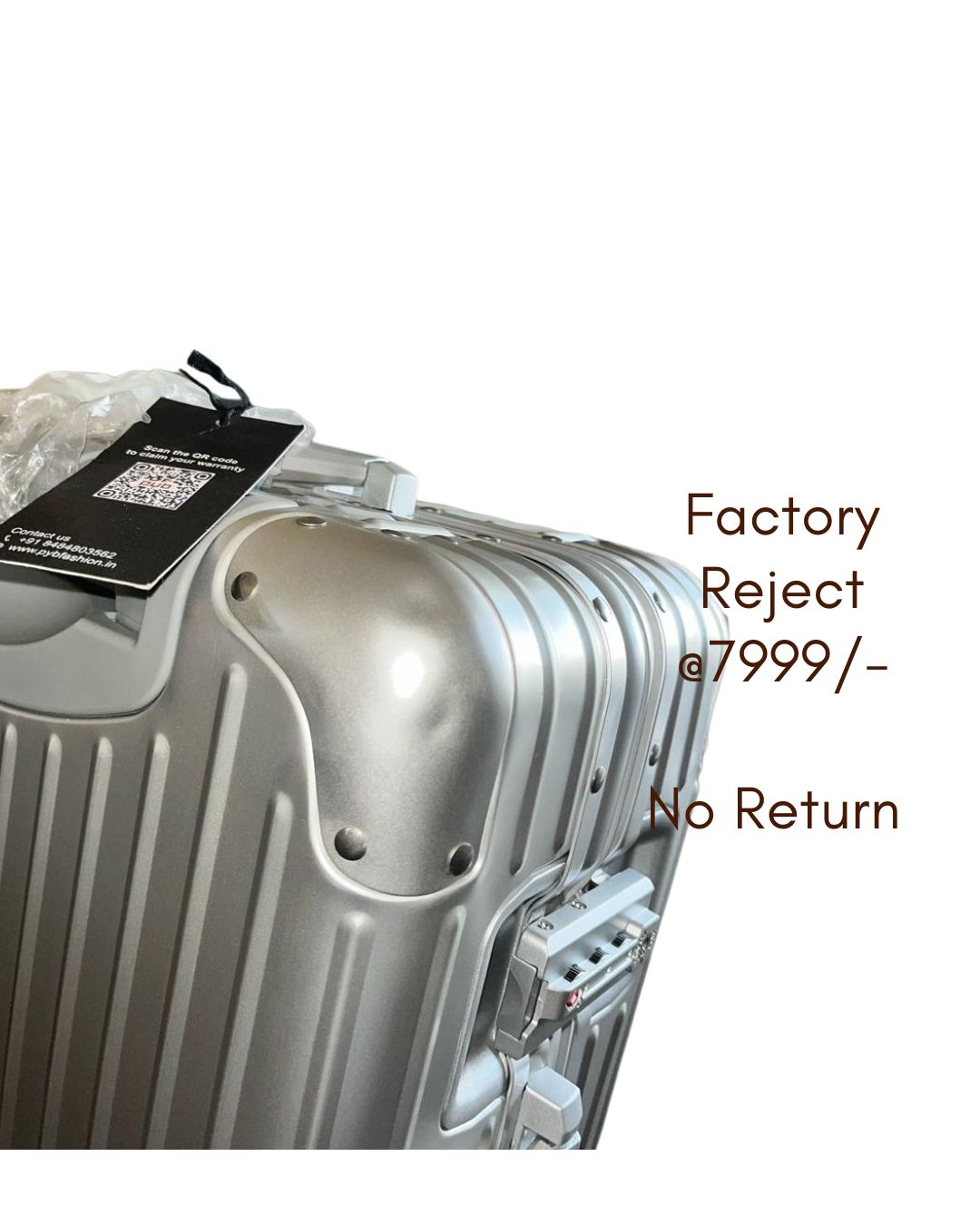 Silver suitcase with a tag labeled 'Factory Reject' 