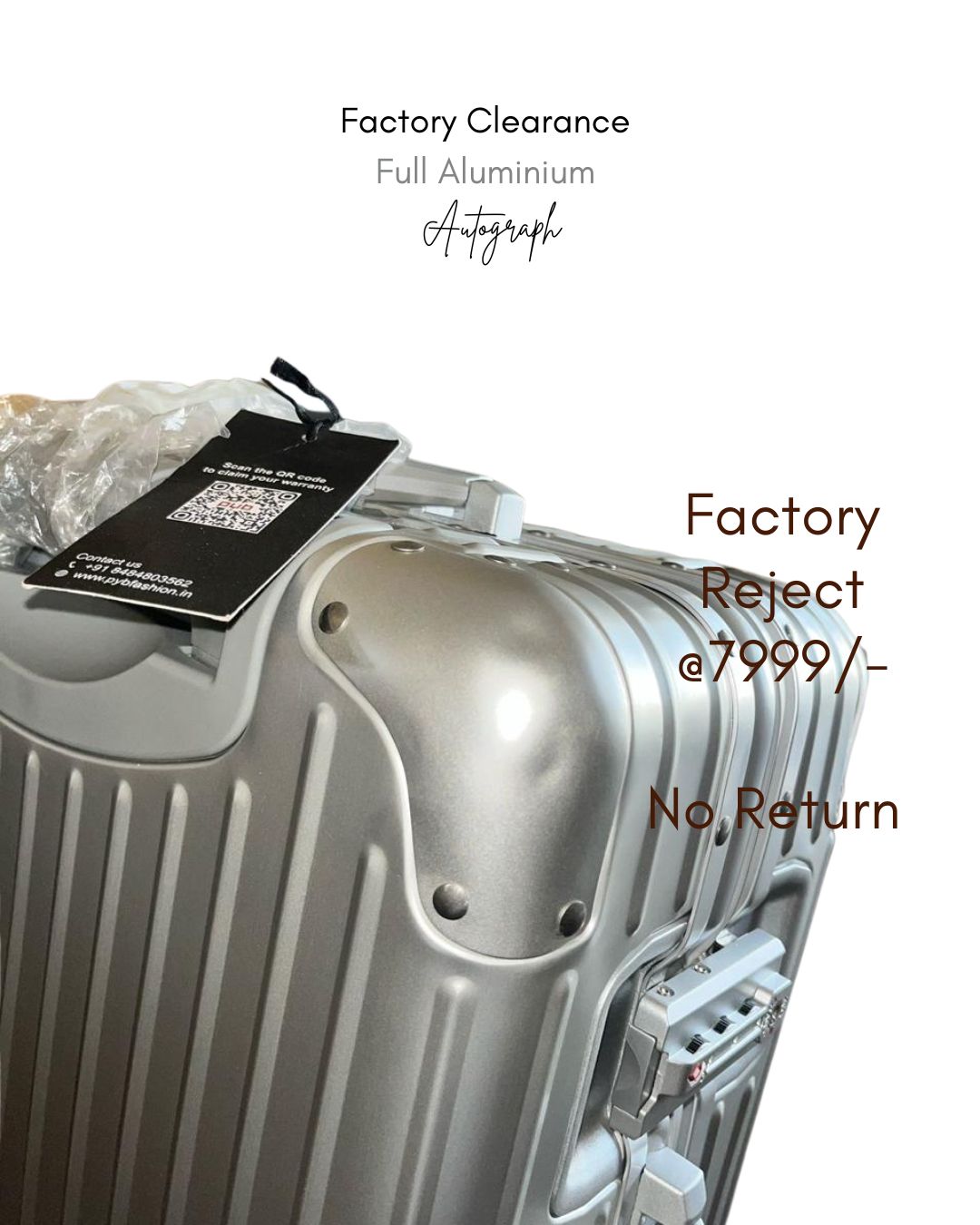 Silver suitcase with a tag labeled 'Factory Reject' on a white background
